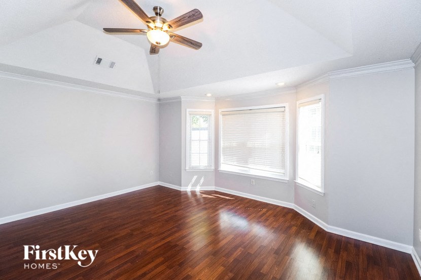 the living room with wood floors and a ceiling fan