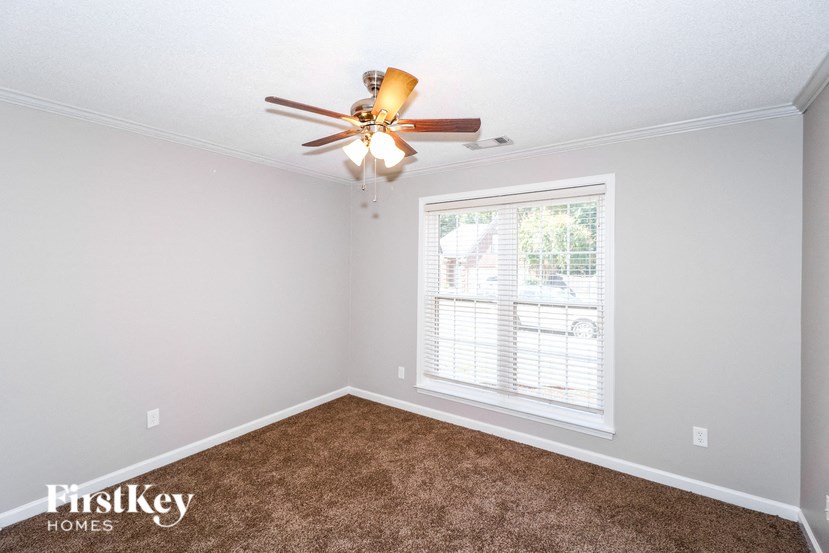 a bedroom with a ceiling fan and a window