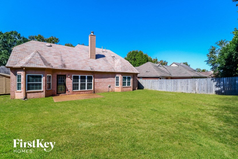 a brick house with a yard and a fence