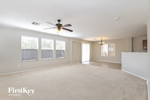 A spacious room with a ceiling fan and windows.