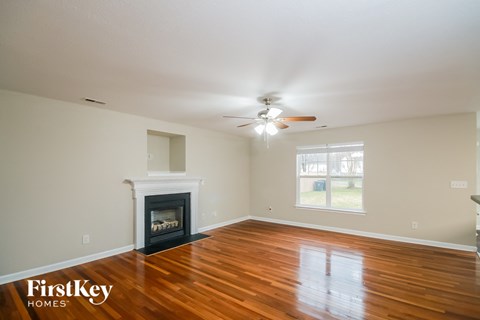 a living room with a fireplace and a ceiling fan