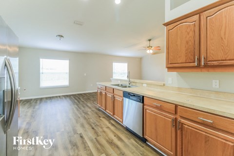 A kitchen with wooden cabinets and a stainless steel dishwasher.