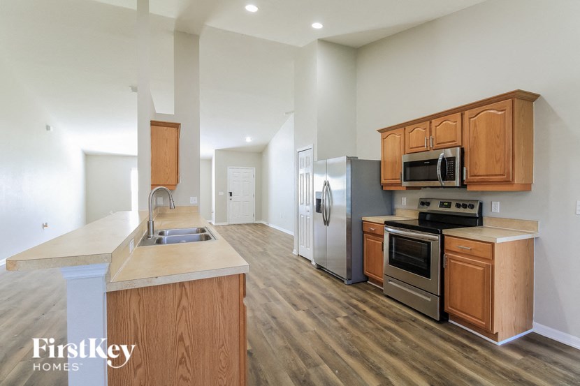 A kitchen with wooden cabinets and a stainless steel refrigerator.