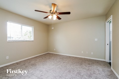 a bedroom with a ceiling fan and a window