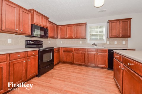 A kitchen with wooden cabinets and a black stove top oven.