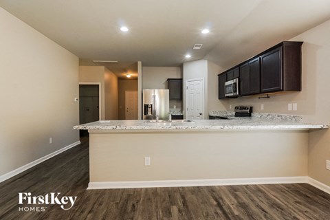 A kitchen with a countertop and cabinets is shown in a FirstKey Homes advertisement.