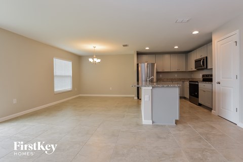 A kitchen with a refrigerator, microwave, and oven.