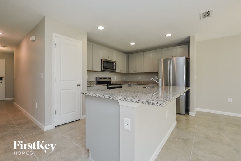 A kitchen with a white island and stainless steel appliances.