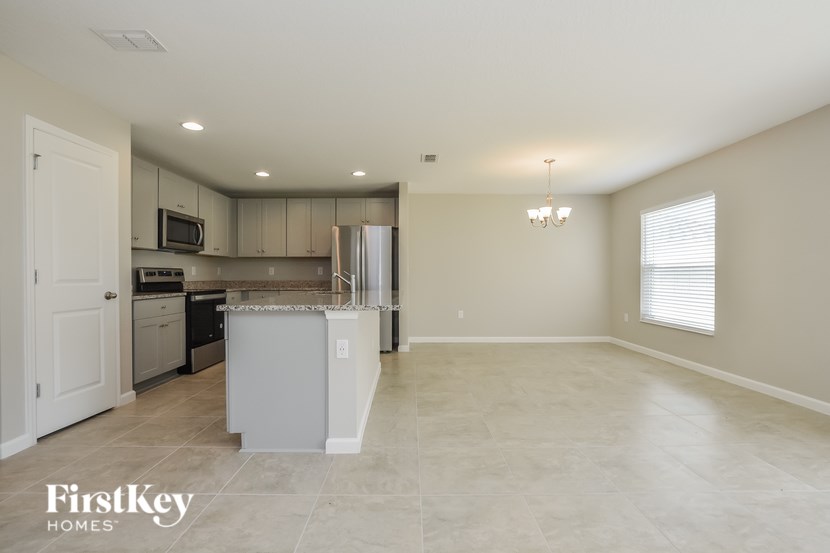 A kitchen with a refrigerator, microwave, and oven.
