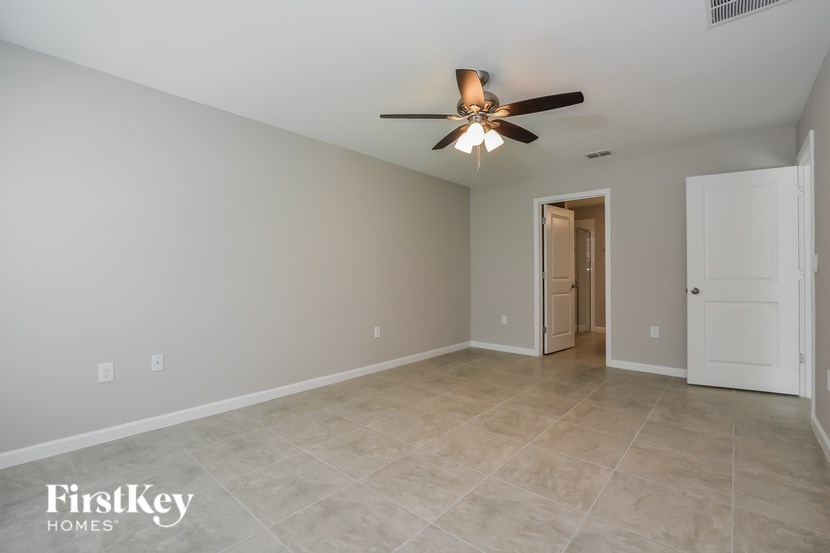 A spacious room with a ceiling fan and tile flooring.