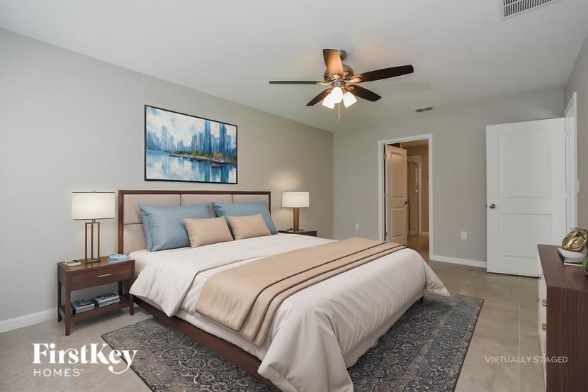 A bedroom with a bed, nightstands, and a ceiling fan.