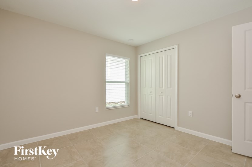 A room with a white door and a window with blinds.