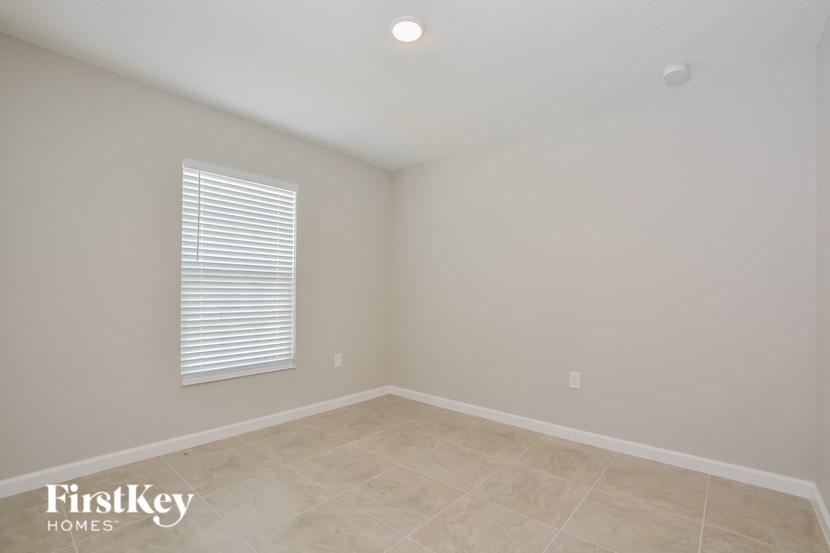 A room with a window and a tiled floor.