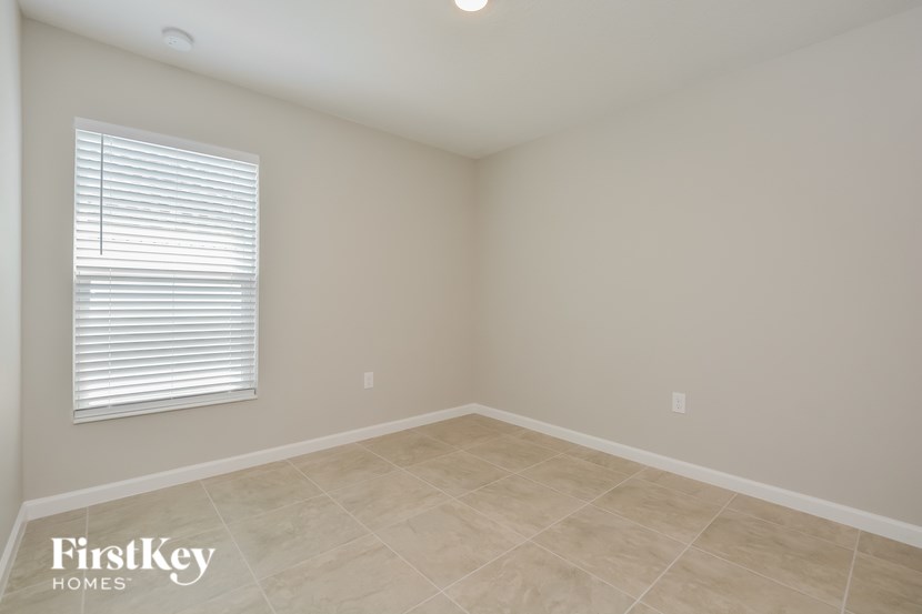 A room with a window and a tiled floor.