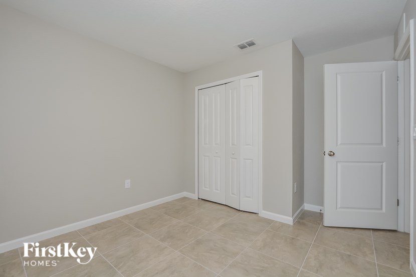A room with two white doors and a tiled floor.