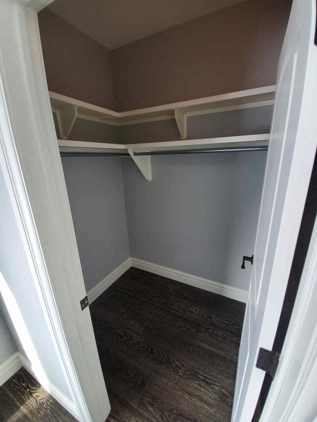 a small closet with shelves and a wood floor