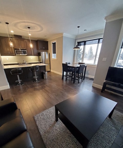 an open kitchen and living room with a table and chairs