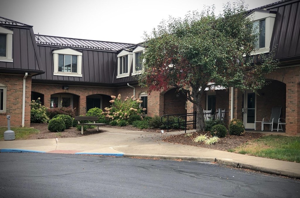 a street in front of a brick house with a sidewalk