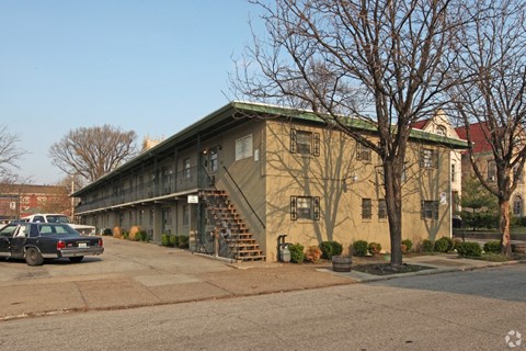 A building with a green roof and a car parked in front.