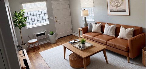 A living room with a brown couch, a wooden coffee table, and a potted plant.