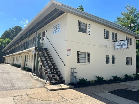 A white building with a sign that says "Oakville Apartments" on it.