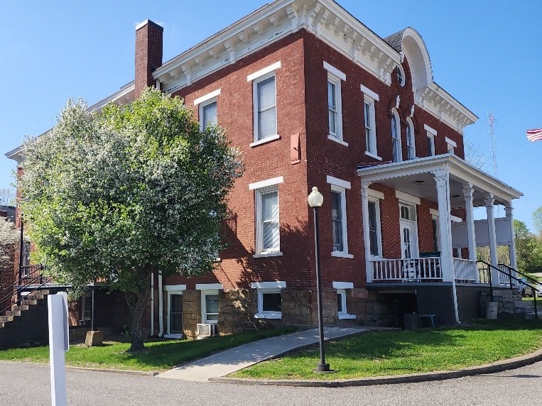 a red brick house with a tree in front of it