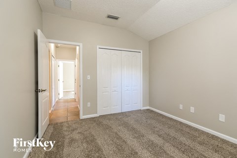 a bedroom with a carpeted floor and a white door