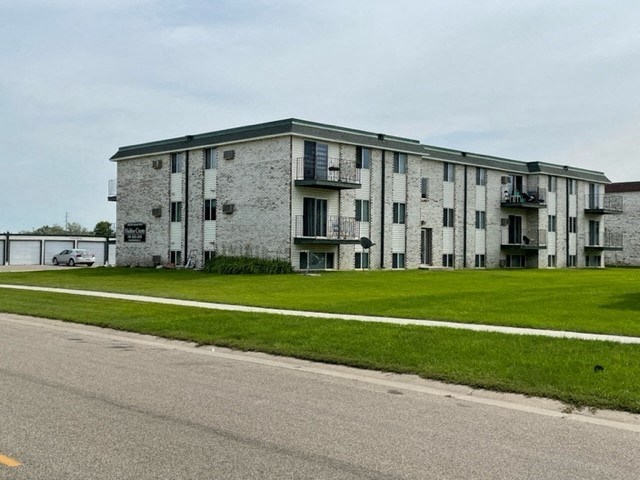 an old building with a green lawn next to a street