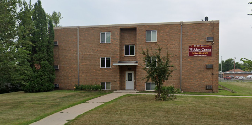a brick building with a sidewalk in front of it