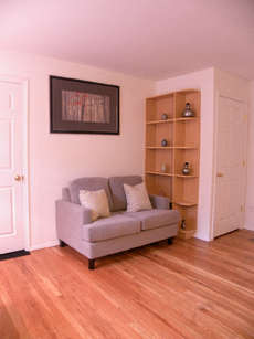 a living room with a couch and a book shelf