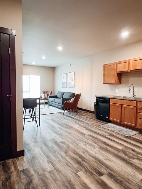 A kitchen with wooden cabinets and a black dishwasher.