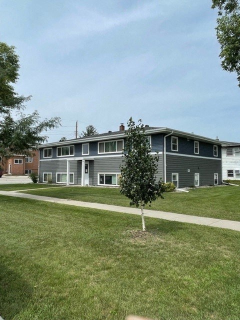 an apartment building with a sidewalk in the grass