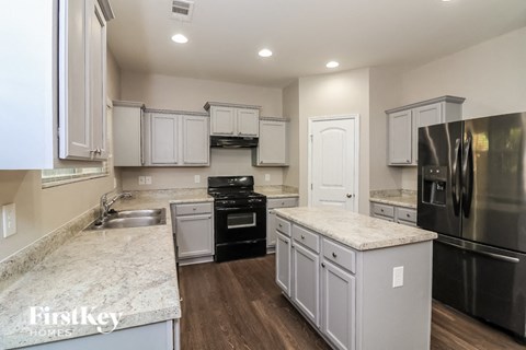 A kitchen with a stove top oven and a refrigerator.