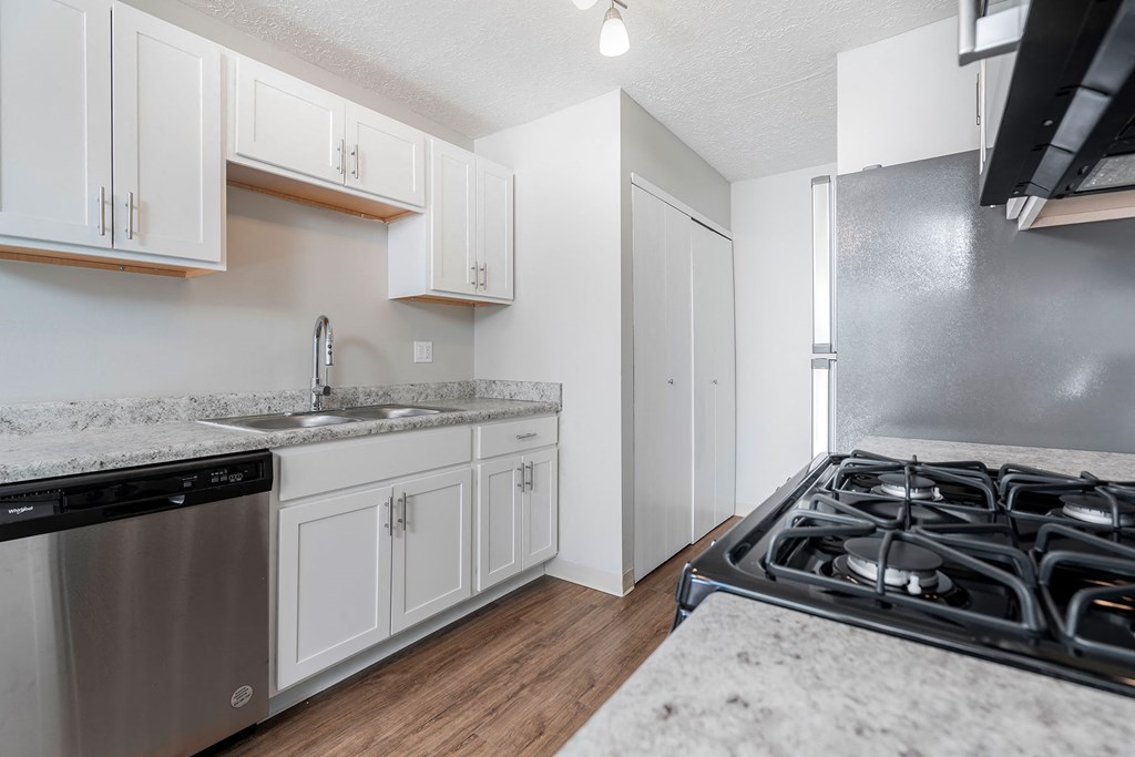 a kitchen with white cabinets and a stove and a sink