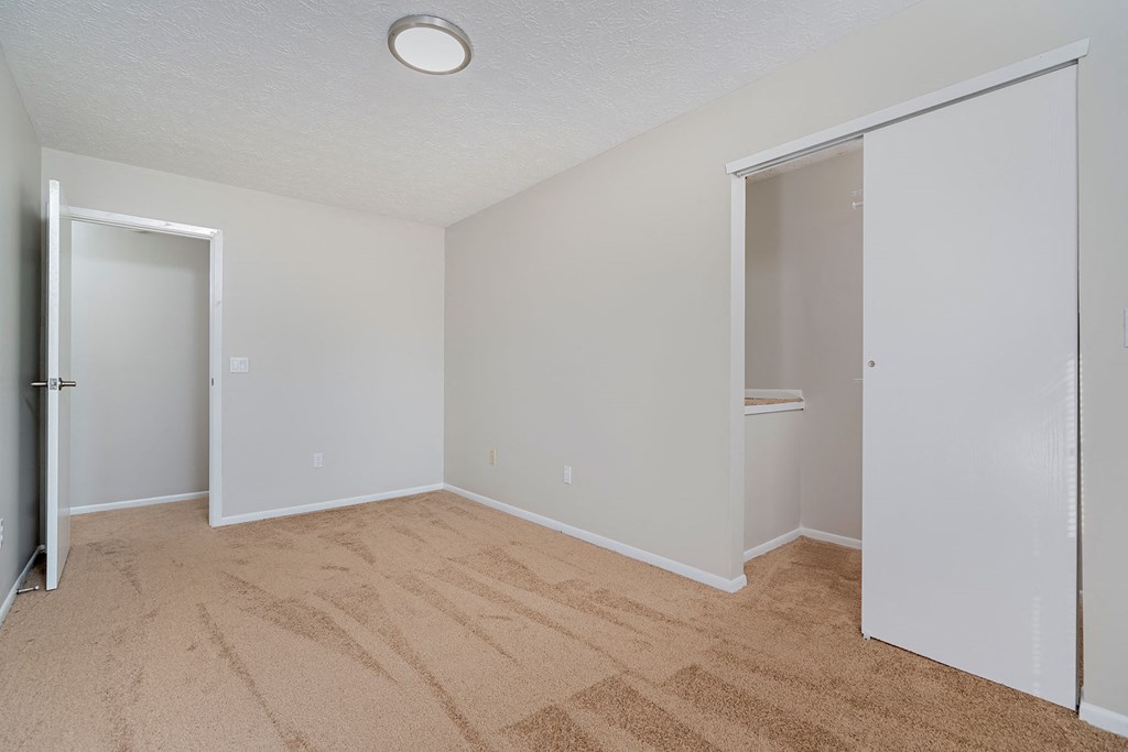 a bedroom with a closet and a door to a bathroom