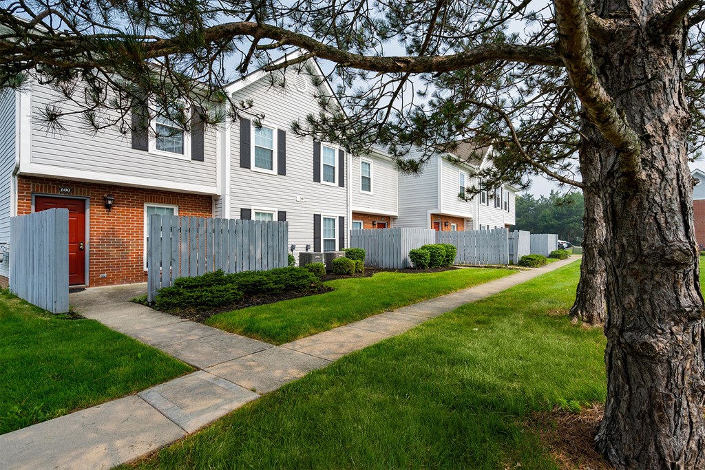 a sidewalk in front of a row of houses