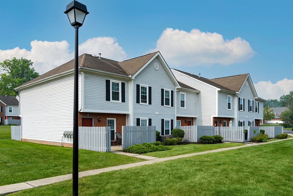 a row of white houses with a street light in front