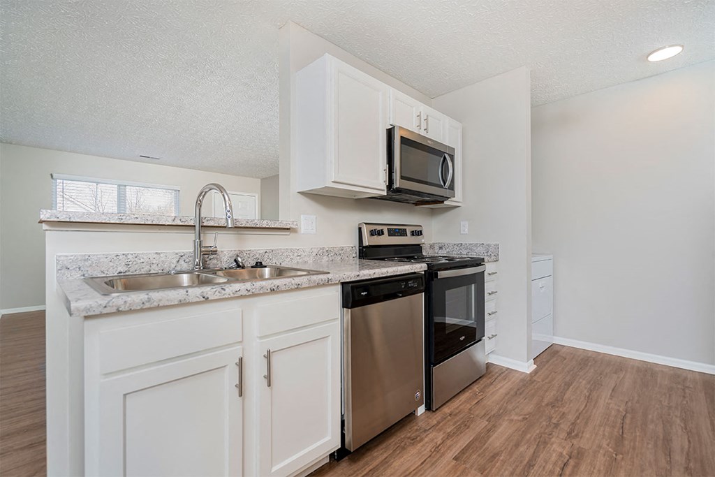 a kitchen with a sink and a stove and a microwave
