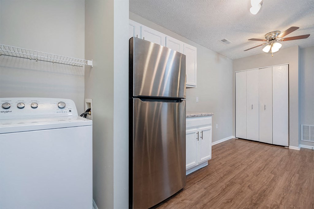 a kitchen with a stainless steel refrigerator and white cabinets