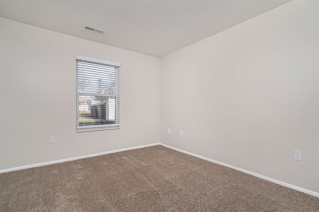 an empty room with carpet and a window