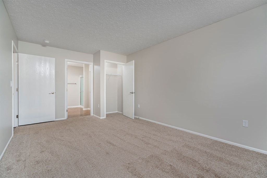 an empty living room with white walls and carpet