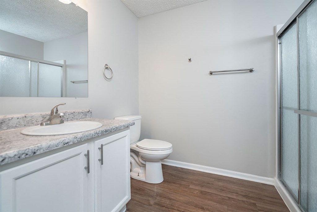 a bathroom with a toilet and a sink and a shower