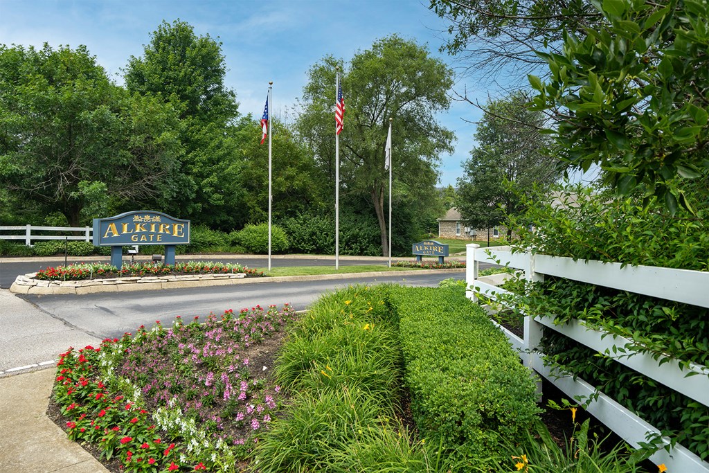 a street corner with flags and a white fence and a sign