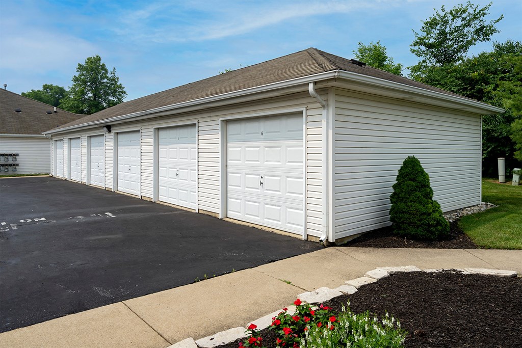 a white garage with white doors on the side of a house