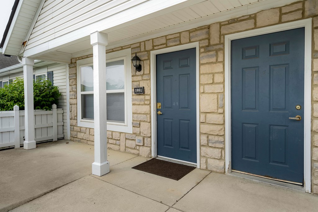 the front of a house with two blue doors