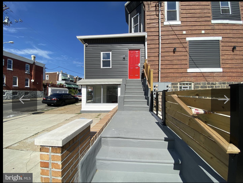the front porch of a house with a red door