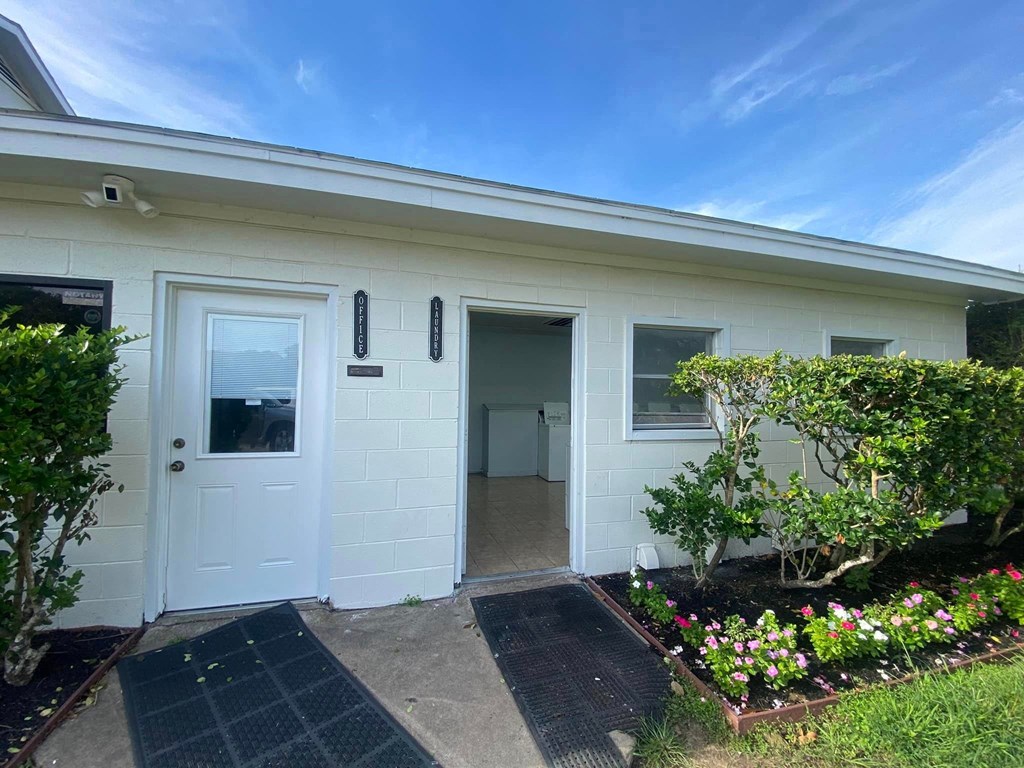the front of a white house with a white door