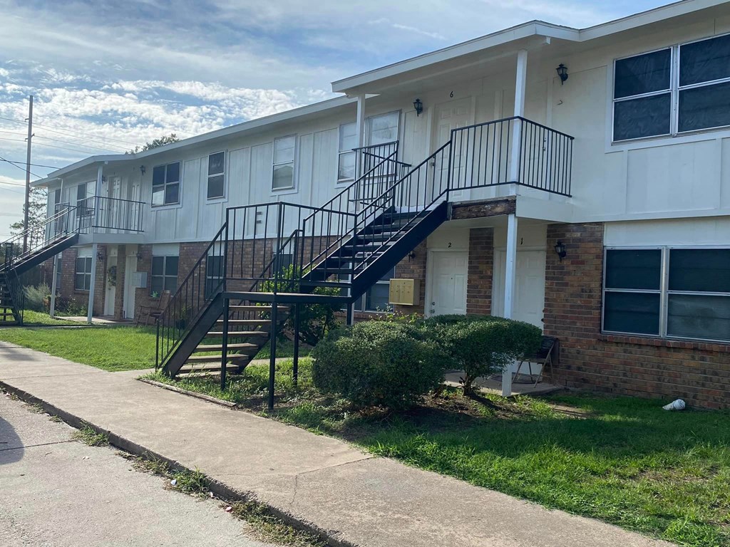 a building with stairs and a sidewalk in front of it