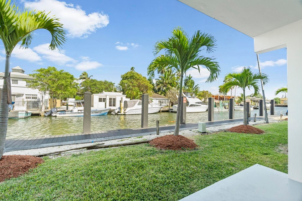 a view of a marina with boats and palm trees