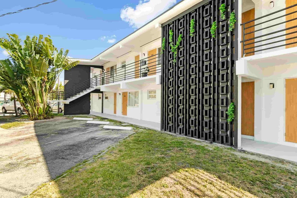 a modern house with a yard and a black and white fence